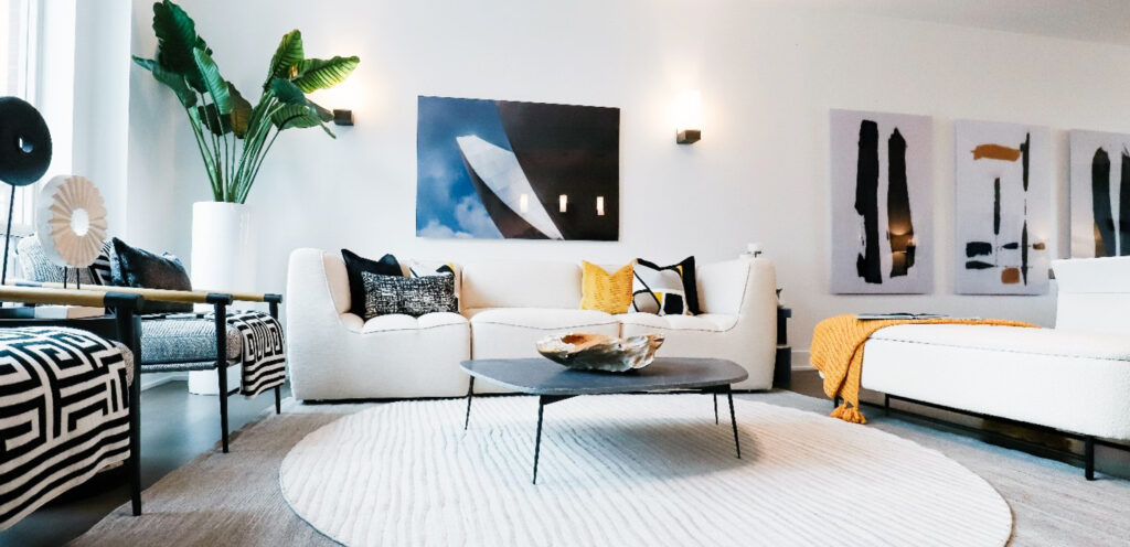 Incorporating layered rugs into the design brought a new dimension of interest and opulence to the area. This large condo, originally one expansive living space, was transformed with the addition of modern rental furniture, with depth and texture created through strategic rug layering. This method not only accentuated the focal point of the room but also introduced an enhanced level of style. 