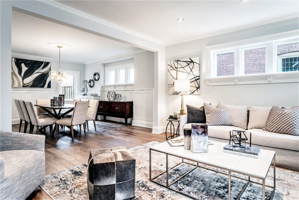 In the after photos, the space now radiates with a newfound brightness. The solution involved a complete overhaul: outdated furniture was replaced with light-colored rentals that perfectly accent the newly painted white walls, instantly revitalizing the space. The transformation was completed with a thorough update to the lighting — a change that not only illuminated the area but also brought a sense of contemporary flair that had been missing from the home. 